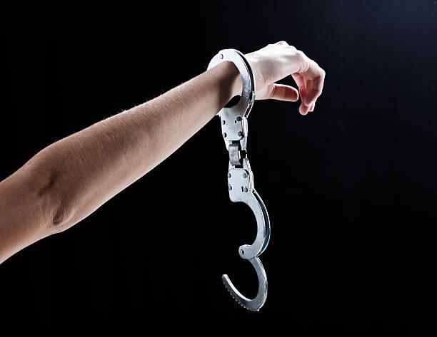 person free from handcuffs, indicating being free from jail
